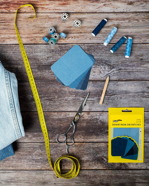 Denim Iron-On Patch Kit With 12 Patches In Three Blue Shades For Inside And Outside Glue Durable Repair For Jeans And Jackets Three Inch By Four And A Quarter Inch Easy DIY Embellishment To Patch Holes And Level Up Your Style. Blue denim patches with sewing tools and measuring tape