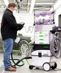 Man using Cubitron II Net Disc Roll 31653 for sanding, with Festool equipment in auto body shop, 6 inch 180 plus grit 50 discs per roll