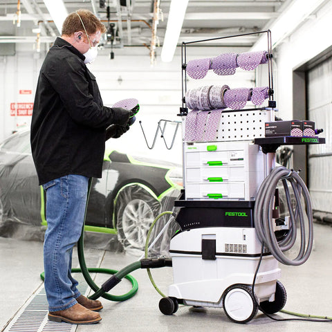 Man using Cubitron II Net Disc Roll 31653 for sanding, with Festool equipment in auto body shop, 6 inch 180 plus grit 50 discs per roll