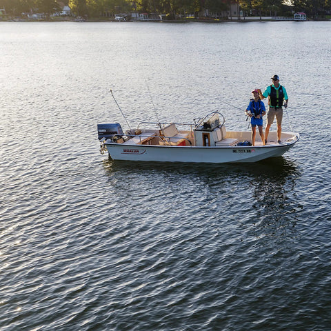 Two people fishing on a motorboat in open water, potential use for Universal Outboard Fuel Line Kit With 7 Foot 3 Eighth Inch Hose UV Resistant EPA CARB Compliant Primer Bulb Connectors Easy Install Fits Any Engine Two Stroke Or Four Stroke Boats.