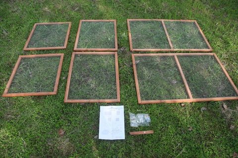 Sturdy Wooden Chicken Coop With Mesh Run For Backyard Poultry And Small Pets assembly pieces on grass, includes mesh panels and instructions.