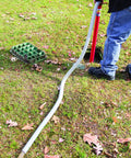 Person using Siphon King 24 Inch Hand Transfer Pump With 36 Inch Hose for water removal on grass terrain