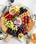 Charcuterie board with fruits, chocolates, honey, and Madagascar Bourbon Pure Vanilla Bean Paste For Baking And Cooking, Thick, Easy Mix Vanilla.