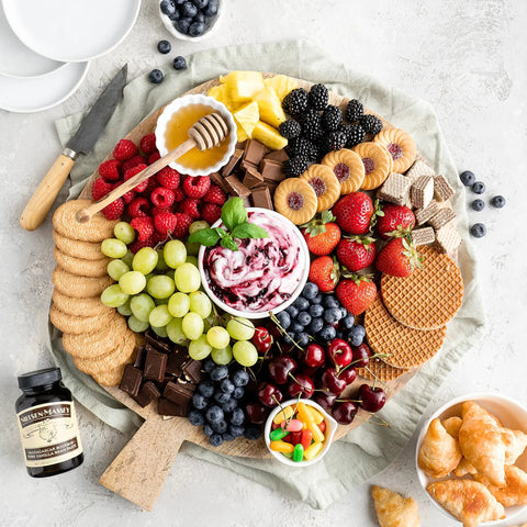 Charcuterie board with fruits, chocolates, honey, and Madagascar Bourbon Pure Vanilla Bean Paste For Baking And Cooking, Thick, Easy Mix Vanilla.