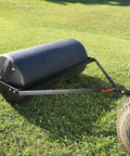 Tow Behind Lawn Roller 18-Inch By 36-Inch Heavy Duty Poly Roller With 40 Gallon Capacity attached to lawn mower on grass