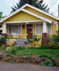 Charming yellow house with porch and garden, showcasing weatherproof outdoor lighting fixture placement.