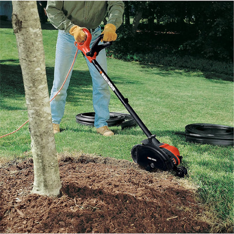 Man using 2 In 1 Electric Lawn Edger And Trencher With 12 Amp Corded Power, 7.5 Inch Cutting Width, in yard for edging