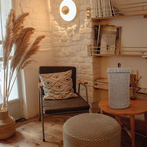 Cozy room with chair, ottoman, and Dope Freestanding Toilet Paper Storage Stand In Natural Jute Weave beside a reed basket.