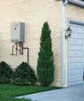 Instant Heat On Demand Outdoor Natural Gas Tankless Water Heater 6.8 Gpm mounted on a brick wall beside greenery.