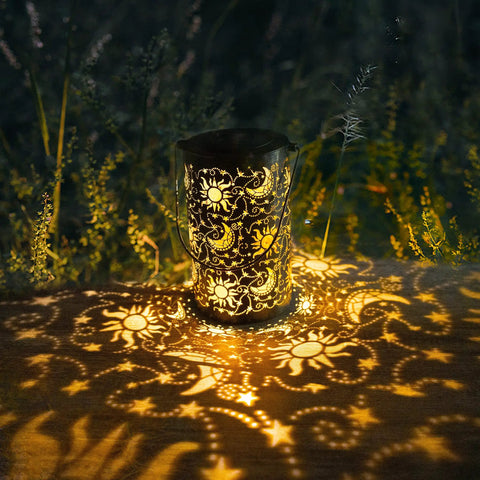 Outdoor Solar Lanterns For Garden Decor, Hanging Metal Sun Moon Star Lights casting patterns on ground in garden setting