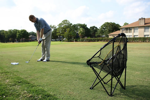 Golfer practicing with Collapsible Golf Chipping Net 23 Inch Folding Frame With 3 Target Baskets Portable Practice Net on a golf course