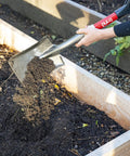 Compact Mini D Handle Square Head Shovel With Soft Grip lifting soil in garden bed, red and black finish, durable spade tool.