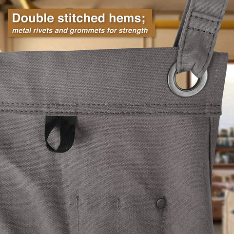 Close-up of gray Waxed Canvas Tool Apron For Woodworking Pros And DIYers showing double-stitched hem and metal grommets.