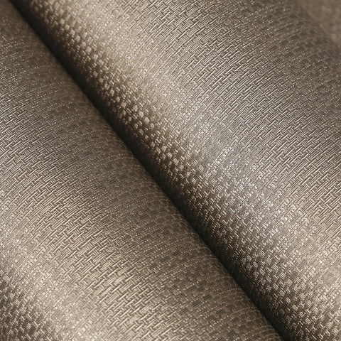 Close-up of taupe metallic grasscloth peel and stick wallpaper roll featuring faux woven texture with subtle shimmer.