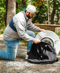 Man using Medium Heat Deflector Carry Bag For Bonfire Accessories Weather Resistant Protective Gear Case with deflector outdoors