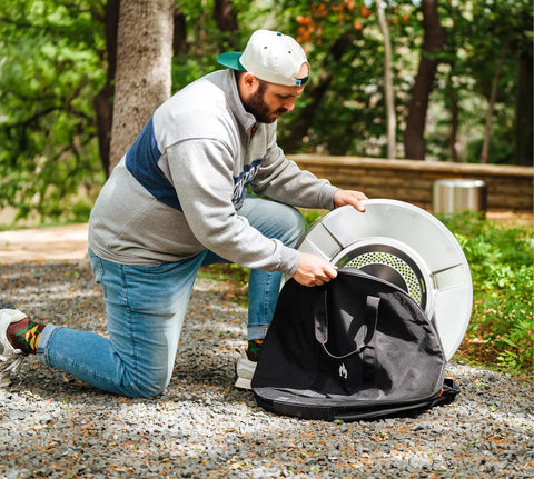 Man using Medium Heat Deflector Carry Bag For Bonfire Accessories Weather Resistant Protective Gear Case with deflector outdoors