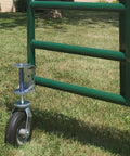 8 Inch Pneumatic Spring-Loaded Gate Caster Wheel attached to a green metal gate, on a grassy surface