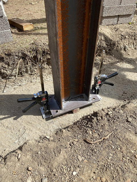 Viking Arm handheld jack/clamp with dual clamps on steel I-beam base at construction site.