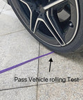 Rock Solid 1/4 Inch By 50 Foot Reinforced PU Air Hose With Swivel Quick Coupler And Male Plug Bend Restrictor Heavy Duty Pneumatic Tubing Built Tough Shop Ready Purple Finish under vehicle tire during rolling test.