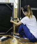 Woman installing Heavy Duty Steel Couch Clamps Keep Your Section Locked Down Adjustable Non Slip Sofa Connectors under a sectional.