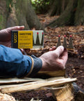 Person holding Sweetfire Biofuel Fire Starters For Camping, Backpacking, And Emergency Prep, Strikeable Tinder Tabs in forest