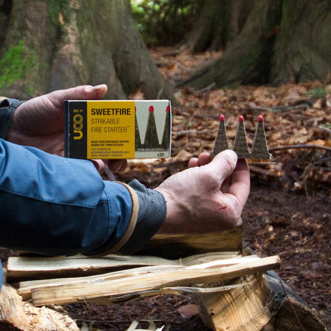 Person holding Sweetfire Biofuel Fire Starters For Camping, Backpacking, And Emergency Prep, Strikeable Tinder Tabs in forest