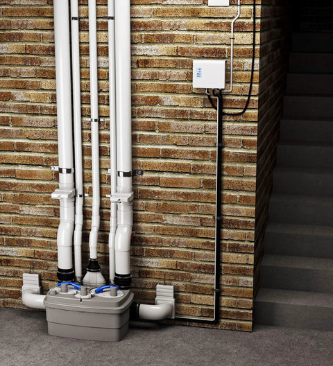 Rugged Duplex Grinder Waste Pump Unit 1 Horsepower Lift Station for Commercial Sites with pipes and lift station installed on brick wall.