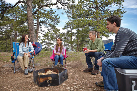 Group sitting around fire pit with Oversize Camping Chair With Cup Holder And Side Pocket, perfect for outdoor activities.