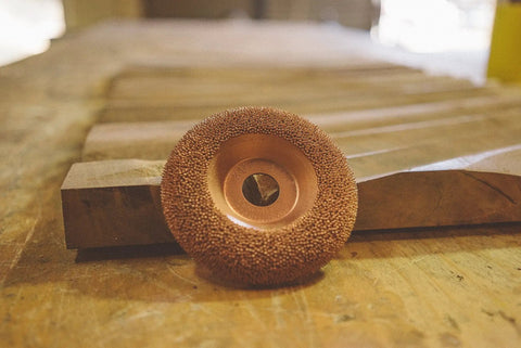 Professional Tungsten Carbide Shaping Disc For Woodworking Angle Grinders 4 Half Inch Diameter And 7 Eighth Inch Bore on wooden surface.