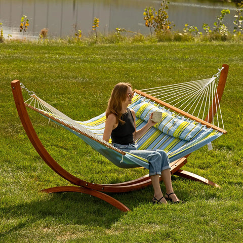 Curved Wood Hammock Stand For Outdoor Use Fits Most 9 To 12 Foot Hammocks 13 Foot Overall Length 400 Pound Capacity Built To Last Two Person Frame In Weather Ready Larch Wood with person relaxing.