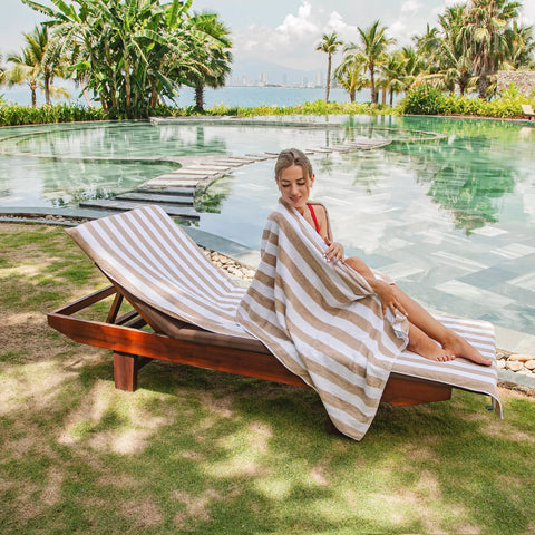 Two Pack California Style Chaise Lounge Cover Towels With Pockets Striped 100 Percent Cotton Cabana Covers for Beach Pool Outdoor Chairs 30 By 85 Inches Beige shown poolside with striped beige and white pattern