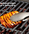 Scalloped tongs from Three Piece Grilling Tool Set With Stainless Steel Turner Scalloped Tongs And Silicone Tool Rest Built In Bottle Opener Non Slip Grip And Tong Holder Designed For One Handed Use With Extra Leverage From A Double Bend holding grilled chicken