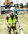 Professional Grade High Visibility Safety Vest Class 2 Reflective Trim Heavy Duty Construction Workwear For Outdoor Crews Safety Green Medium worn by a surveyor using a level.