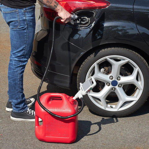 One Hand Electric Fuel Transfer Pump With Flow Control Nozzle And D Battery Power Hands Free Gas Can Pump For Liquids And Water Jugs 2 Point 4 GPM Flow Long Suction Tube For Tall Containers used with a red gas can at a car fuel tank