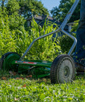 User mowing grass with No Sweat 14 Inch 5 Blade Push Reel Lawn Mower With Ball Bearing Reel And Cushioned T Style Handle Adjustable Cutting Height From 0.5 To 1.75 Inches Heat Treated Alloy Steel Blades Tool Free Adjustments For Easy Yard Work.
