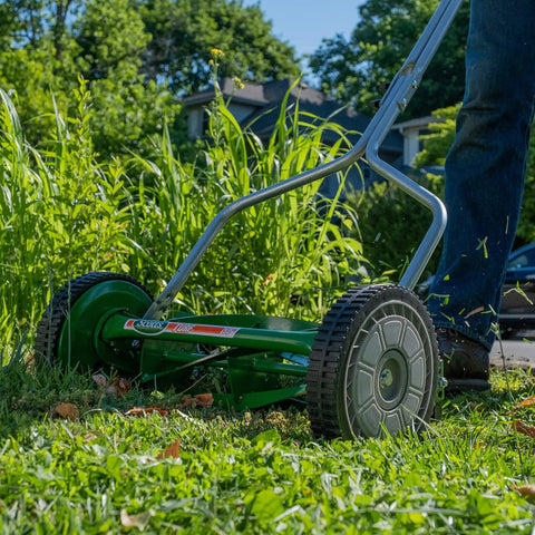 User mowing grass with No Sweat 14 Inch 5 Blade Push Reel Lawn Mower With Ball Bearing Reel And Cushioned T Style Handle Adjustable Cutting Height From 0.5 To 1.75 Inches Heat Treated Alloy Steel Blades Tool Free Adjustments For Easy Yard Work.