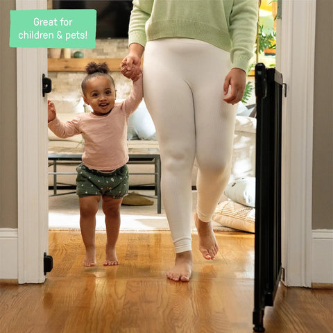 Mother and child walking through Deluxe Stair Gate For Pets And Kids, Super Easy Install No Fuss Secure Build, Black Wood.
