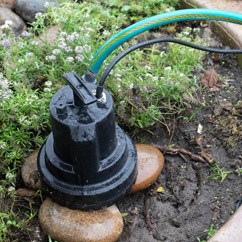 Smart Submersible Water Pump With HydraDetect Auto Operation Portable Electric Pump in garden setup near flowerbed