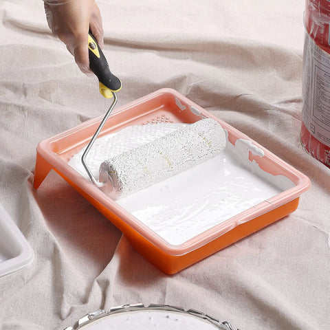 Hand using paint roller in 9 Inch Paint Tray Liners 20 Pack Disposable Plastic Trays for Roller Trays Fits Most Mini Paint Pans