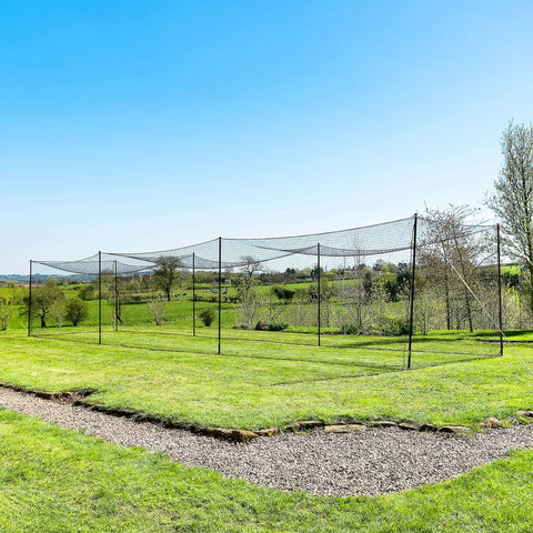 35 Ft Ultimate Baseball Batting Cage With Net And Poles Package set up in a backyard with heavy duty #42 net and galvanized steel uprights.