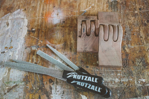 Pro Grade Heavy Duty Eight Inch Half Round Hand Rasp With Slick Ergonomic Soft Grip Handle and tough tungsten carbide coating on workbench.