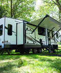 Tough As Nails RV Slide Out Floor Protector Plate shown on travel trailer near folding chairs under an awning.