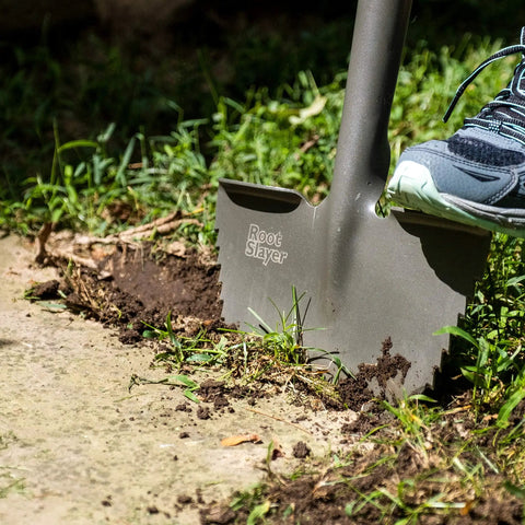 Manual Serrated Garden Edger For Landscaping And Clean Lawn Borders in use on garden soil with background greenery.