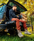Man sitting on truck tailgate holding Rechargeable Solar Powered Flashlight Lantern For Camping And Outdoors USB And Solar Charging Emergency Power Bank Lifesaver Lantern For Power Outages Hiking And Survival Car Camping Essential.