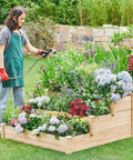 Person watering plants in a Three Tier Raised Garden Bed With 47 Inch Square Footprint And 22 Inch Height Wooden Planter For Backyard Or Patio Outdoor Elevated Flower Box For Vegetables And Herbs