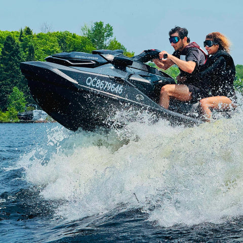 Two people jet skiing wearing Frameless Ultralight Black Mirror Swim Goggles With VisiClear Nanotech Anti Fog Lens And 100 Percent UV Protection for watersports.