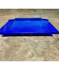 Heavy Duty Low Profile Drum Scale Built Tough With Smooth Hinged Ramps For No Sweat Barrel Rolling And Rock Solid Weighing Capability Up To 5000 Pounds With Spot On One Pound Accuracy NTEP Approved blue steel scale platform on warehouse floor.