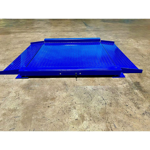 Heavy Duty Low Profile Drum Scale Built Tough With Smooth Hinged Ramps For No Sweat Barrel Rolling And Rock Solid Weighing Capability Up To 5000 Pounds With Spot On One Pound Accuracy NTEP Approved blue steel scale platform on warehouse floor.