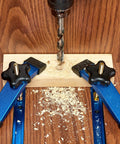 Heavy Duty Aluminum T Track Hold Down Clamps Blue Set With Five Star Knobs And T Bolts in use securing wood for drilling.