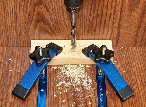 Heavy Duty Aluminum T Track Hold Down Clamps Blue Set With Five Star Knobs And T Bolts in use securing wood for drilling.